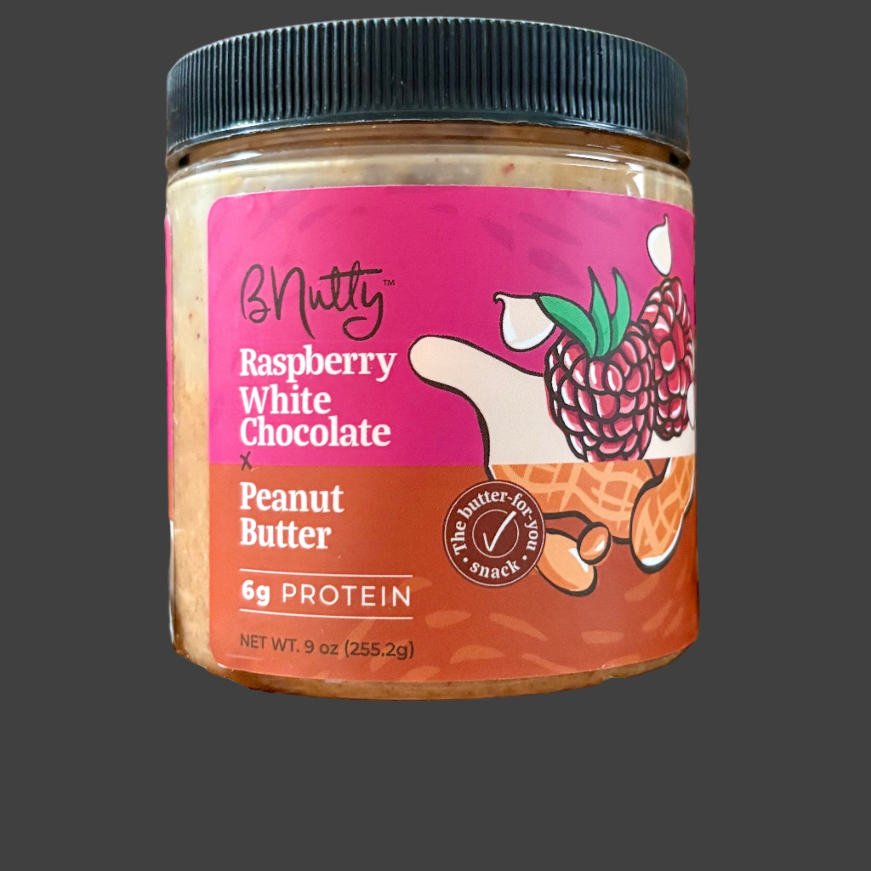 Jar of raspberry white chocolate peanut butter on crinkled brown paper