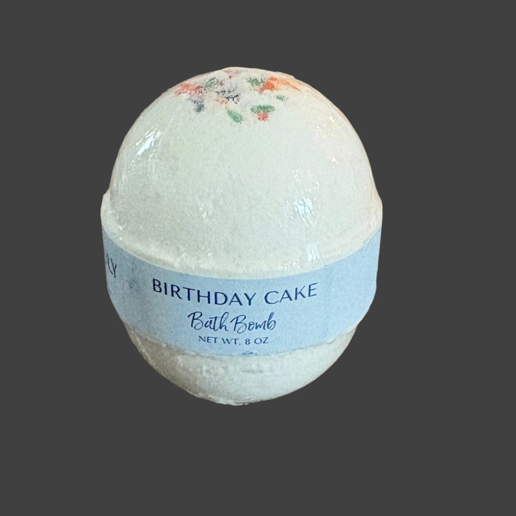 Bath bomb labeled 'Birthday Cake' on a wooden surface