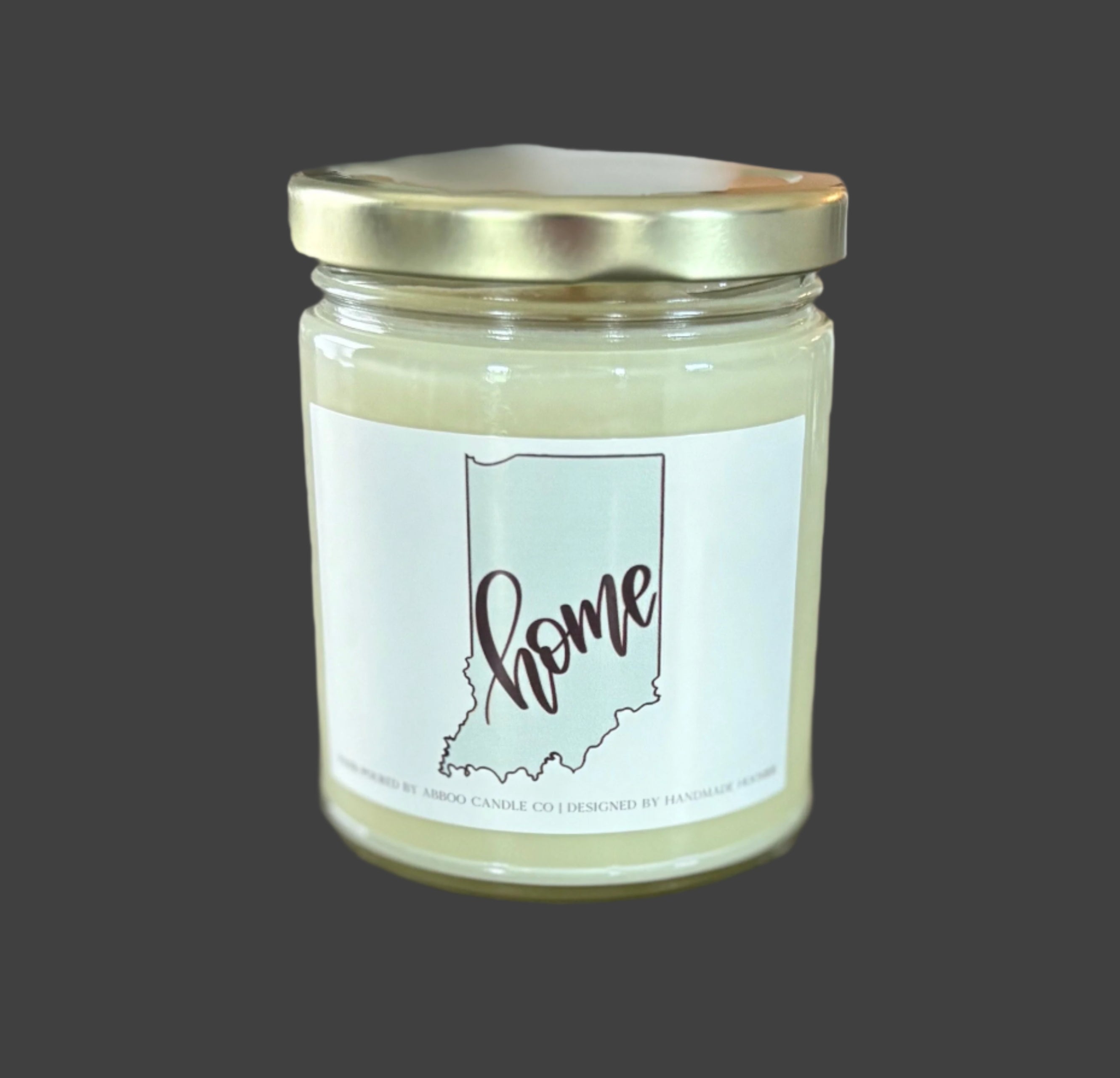 Soy candle locally made with an Indiana "home" label on a wooden surface