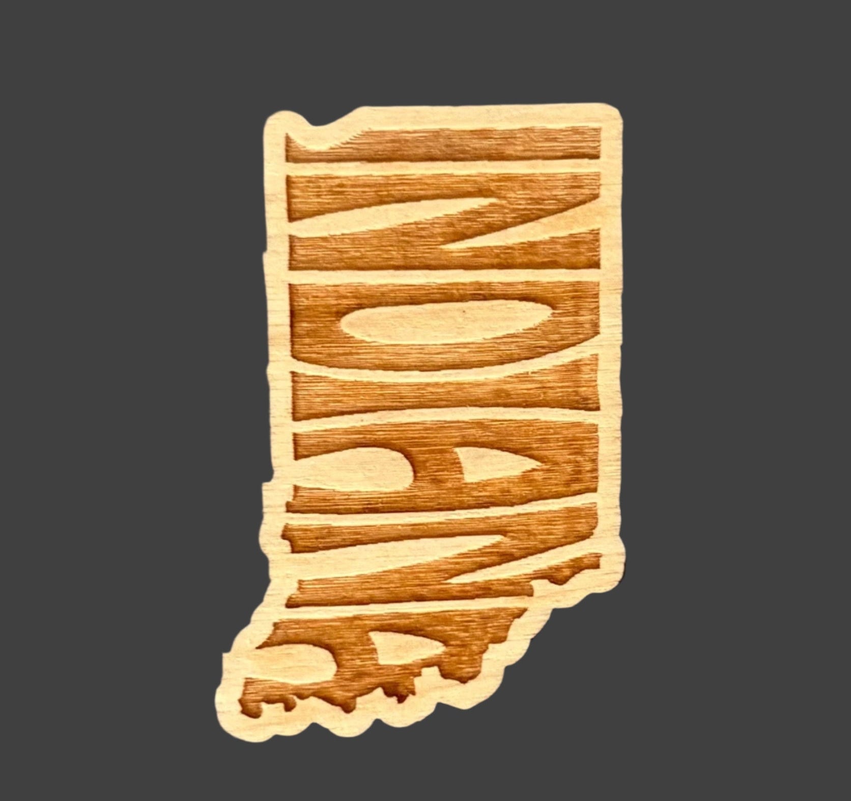 Wooden Indiana-shaped magnet on a gray surface