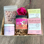 Gift set with skincare products and tea on a wooden surface