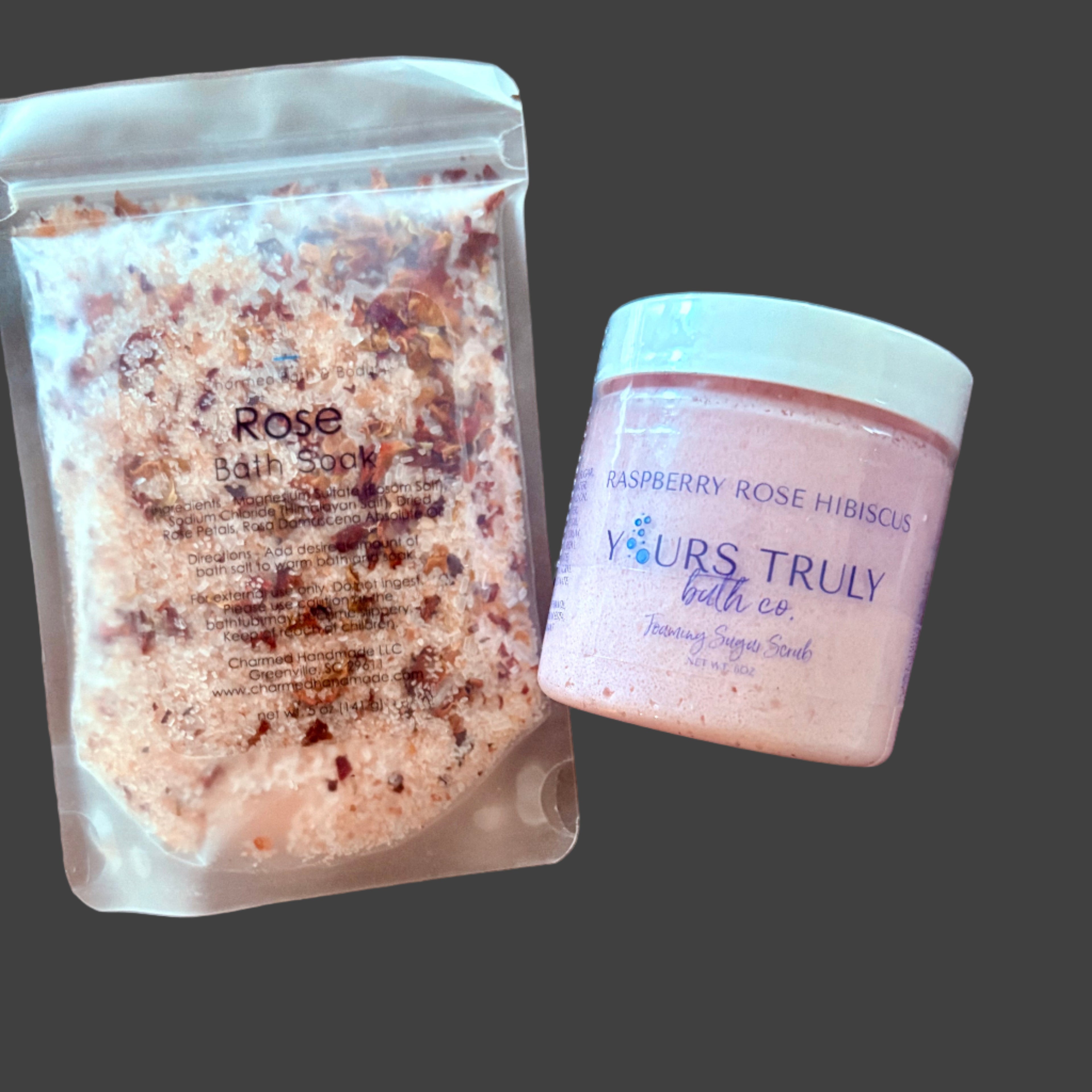 Rose bath soak and raspberry rose hibiscus bath scrub on a wooden surface