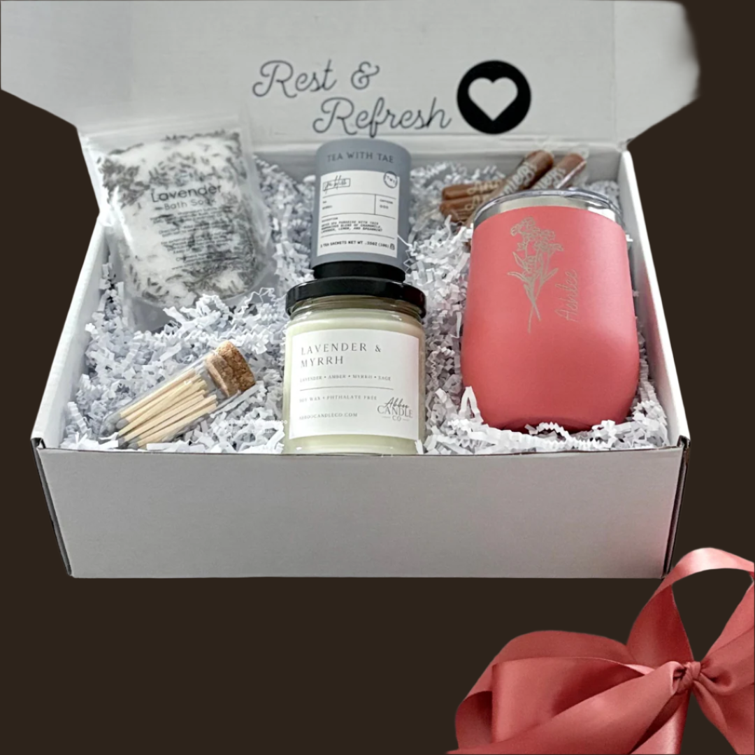 Gift box with a personalized wine tumbler, lavender bath salts, lavender and myrrh candle, matches, tea and caramels.