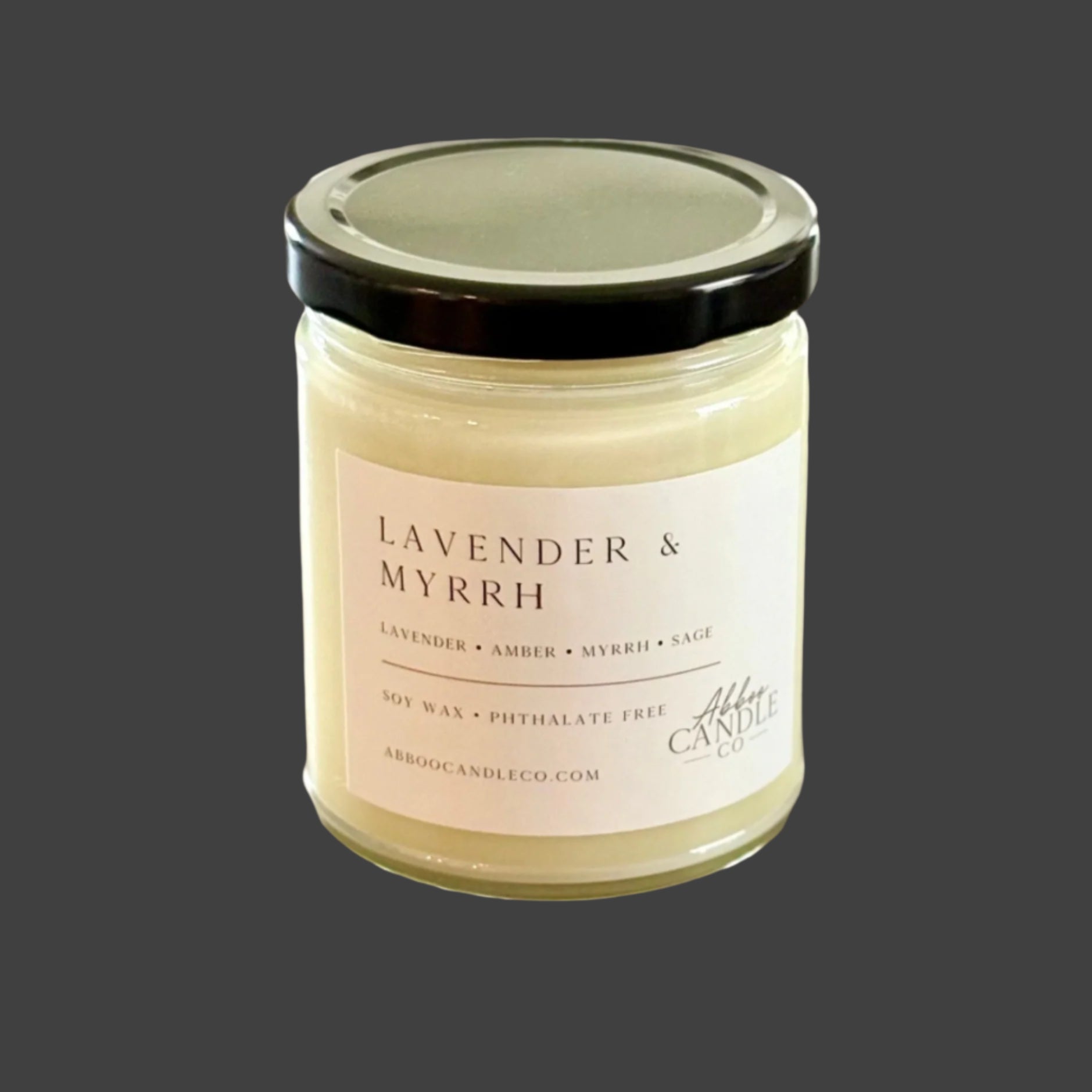 Candle labeled 'Lavender & Myrrh' on a wooden surface