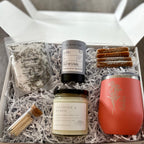 Gift box with lavender soap, candle, and other items on a wooden surface