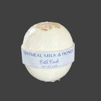 Oatmeal Milk & Honey bath bomb on a wooden surface 